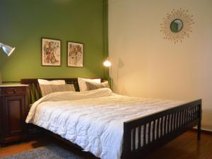 Un dormitorio con una cama grande y una pared verde en Delightful Holiday Home in Denee With Terrace en Denée