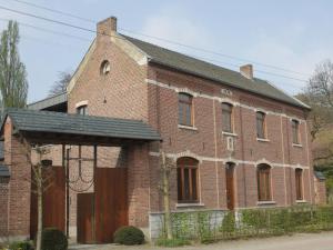 un antiguo edificio de ladrillo rojo con techo negro en Beautiful former monastery completely renovated, en Sint-Truiden