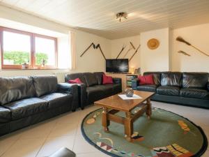 ein Wohnzimmer mit einem Sofa und einem Tisch in der Unterkunft Modern Cottage with Private Garden in Waimes in Weismes