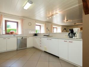 eine große weiße Küche mit weißen Schränken und Geräten in der Unterkunft Modern Cottage with Private Garden in Waimes in Weismes