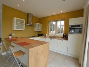 cocina con armarios blancos y encimera de madera en Soothing Holiday Home with Recreation Room, en Sint-Amands