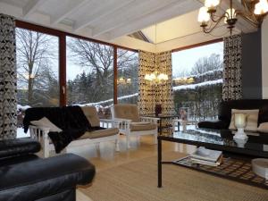 uma sala de estar cheia de mobiliário e uma grande janela em Contemporary Chalet in Malmedy near Forest em Malmedy