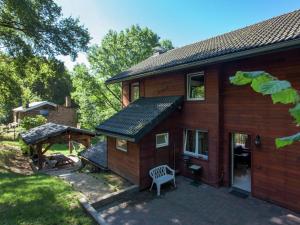 a wooden house with a bench in front of it at Modern Chalet in Sougné-Remouchamps near Forest in Aywaille