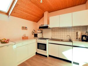 Il comprend une cuisine avec des appareils blancs et un plafond en bois. dans l'établissement Beautiful Apartment near Forest in Nidrum, à Nidrum