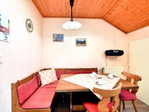 een eetkamer met een houten tafel en rode stoelen bij Beautiful Apartment near Forest in Nidrum in Nidrum