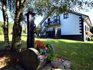 a house with a tree and flowers in the yard at Beautiful Apartment near Forest in Nidrum in Nidrum