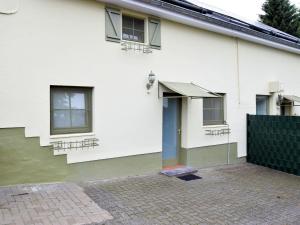 uma casa branca com uma porta azul e janelas em Charming holiday home in St Vith with terrace em Heuem