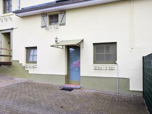 uma casa branca com uma porta e um toldo em Charming holiday home in St Vith with terrace em Heuem