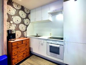 uma cozinha com armários brancos e um forno com placa de fogão em Charming holiday home in St Vith with terrace em Heuem
