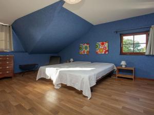a blue bedroom with a large bed in a room at Friendly and rustic family home with fireplace in Stavelot
