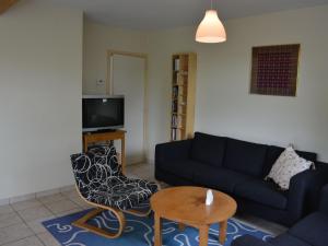 a living room with a couch and a table at Apartment with private garden in the heights of Bouillon in Bouillon