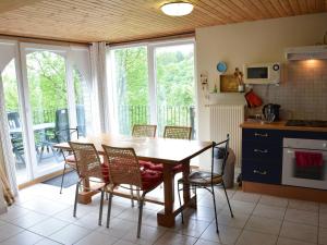 a kitchen with a wooden table and chairs in a room at Apartment with private garden in the heights of Bouillon in Bouillon