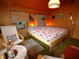 - une chambre avec un grand lit et une chaise dans l'établissement Pristine home in a charming village large grassy sunbathing area view of the M nch and Jungfrau, à Wilderswil