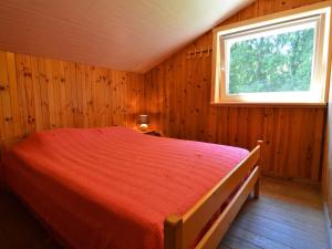 a bedroom with a red bed with a window at Welcoming Cottage in Hatrival with Terrace in Saint-Hubert