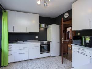 a kitchen with white appliances and a clock on the wall at Friendly and rustic family home with fireplace in Stavelot