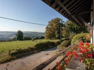 a view from the porch of a house with flowers at Friendly and rustic family home with fireplace in Stavelot