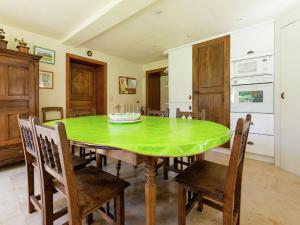 une salle à manger avec une table et des chaises vertes dans l'établissement Cosy holiday house near La Roche, à Rendeux