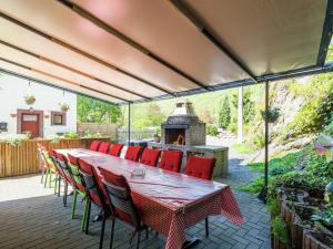 een patio met een tafel en stoelen en een open haard bij Lovely Holiday Home in Marcourt in Marcourt