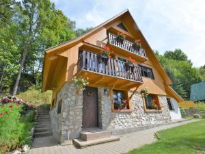 a house with a balcony with flowers on it at Luxury Chalet near Ski area in Benecko in Mrklov