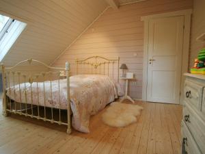 een slaapkamer met een bed met een sprei en een tapijt bij Countryside Chalet in Bomal sur Ourthe with Sauna Balcony in Bomal