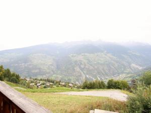 uma vista para uma montanha a partir de uma cerca de madeira em Chalet in H r mence with Sauna Ski Whirlpool em Les Collons