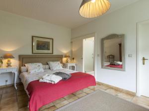 a bedroom with a bed with a red blanket at Modern Holiday Home in Zingem with Garden in Zingem