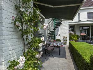Modern Holiday Home in Zingem with Garden في Zingem: فناء به طاولة وزهور على جانب المنزل