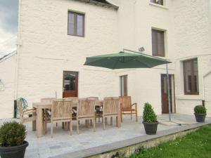 een patio met een tafel en een groene parasol bij Luxurious Holiday Home with Garden in Gimn e in Doische