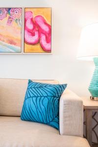 a blue pillow sitting on top of a couch with paintings at Margaritaville Resort Palm Springs in Palm Springs