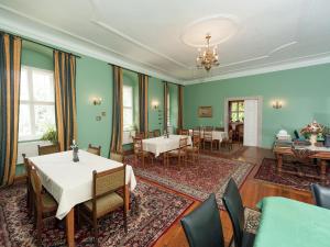 ein Esszimmer mit grünen Wänden, Tischen und Stühlen in der Unterkunft Vintage Apartment in Arzberg Triestewitz in Arzberg