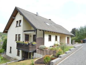 Casa blanca pequeña con balcón y plantas en holiday home in xheim Niederehe with garden, en Niederehe