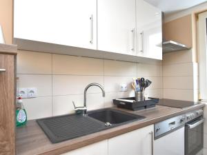 a kitchen with white cabinets and a sink at Apartment with private terrace in Friedrichshöhe