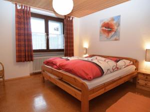 sypialnia z łóżkiem z czerwonymi poduszkami w obiekcie Quiet holiday home with terrace w mieście Korbach