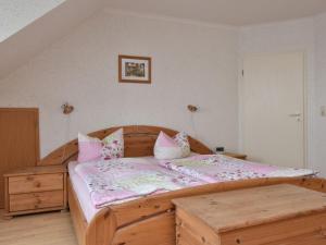 um quarto com uma cama de madeira e almofadas cor-de-rosa em Charming Apartment in Rerik Mecklenburg with Sea View em Rerik