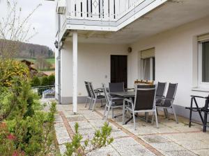 um pátio com uma mesa e cadeiras numa casa em Apartment with private terrace in the mountainous region of northern Hesse em Homberg