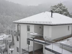 ein weißes Gebäude mit Schnee auf dem Dach in der Unterkunft Apartment on the 2nd floor with balcony and nice views in the centre of Willingen in Willingen