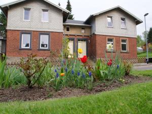 a house with a flower garden in front of it at Holiday home near ski area in Rechenberg-Bienenmühle