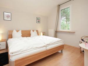 um quarto com uma grande cama branca e uma janela em Holiday home near ski area em Rechenberg-Bienenmühle