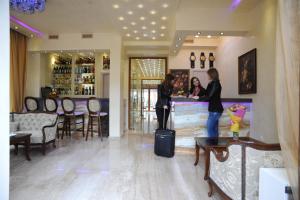 two women standing in a bar with their luggage at Hotel Adria in Sofia