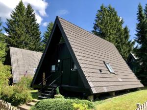 ein schwarzes Haus mit einem Gameradach in der Unterkunft Wooden chalet with oven, in Oberharz near a lake in Clausthal-Zellerfeld