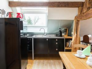 a kitchen with a black refrigerator and a sink at Schleiden Timber-Frame Retreat in Schleiden