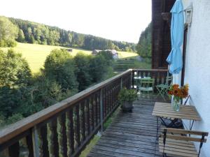 a wooden deck with a table and a bench on it at Secluded Apartment in Sch nsee Nearby the Forest in Schönsee