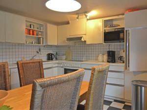 cocina con mesa, sillas y nevera en Holiday home in Sauerland with garden, en Schmallenberg