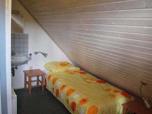 a small bedroom with a bed and a sink at Holiday home in Reimboldshausen with balcony in Kemmerode