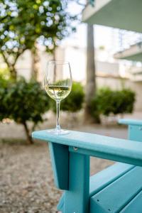 a glass of wine sitting on top of a wooden bench at Margaritaville Resort Palm Springs in Palm Springs