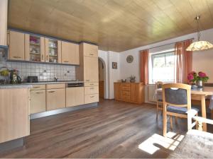 a large kitchen with wooden cabinets and a table at Cozy Holiday Home in Schiefweg with Garden in Waldkirchen