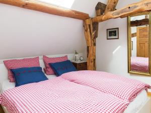 a bedroom with a bed with red and blue pillows at Vintage Apartment with Garden in Schleiden