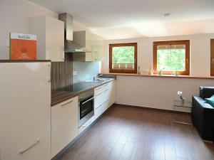 EslarnにあるModern apartment in Bavaria with gardenのキッチン(白いキャビネット、カウンタートップ付)