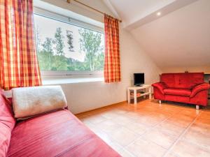 ein Wohnzimmer mit einem roten Sofa und einem Fenster in der Unterkunft Splendid Holiday Home in Untervalme near Ski Area in Schmallenberg