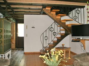 a living room with a staircase and a television at Converted old mill in St Georgen in the Black Forest in Sankt Georgen im Schwarzwald